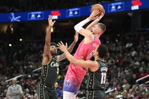 Mar 28, 2023; Washington, District of Columbia, USA; Washington Wizards center Kristaps Porzingis (6) looks to pass between Boston Celtics guard Malcolm Brogdon (13) and guard Marcus Smart (36) during the second half at Capital One Arena. Mandatory Credit: Brad Mills-USA TODAY Sports