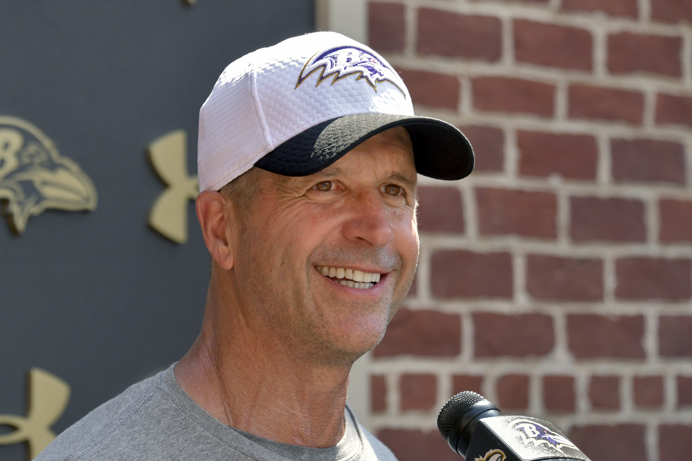 Head coach John Harbaugh talks to the media after practice...