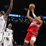 Oct 14, 2024; Brooklyn, New York, USA; bWashington Wizards shooting guard Jordan Poole (13) shoots a jump shot against Brooklyn Nets power forward Dorian Finney-Smith (28) and Brooklyn Nets point guard Dennis Schroder (17) during the second half at Barclays Center. Mandatory Credit: Gregory Fisher-Imagn Images