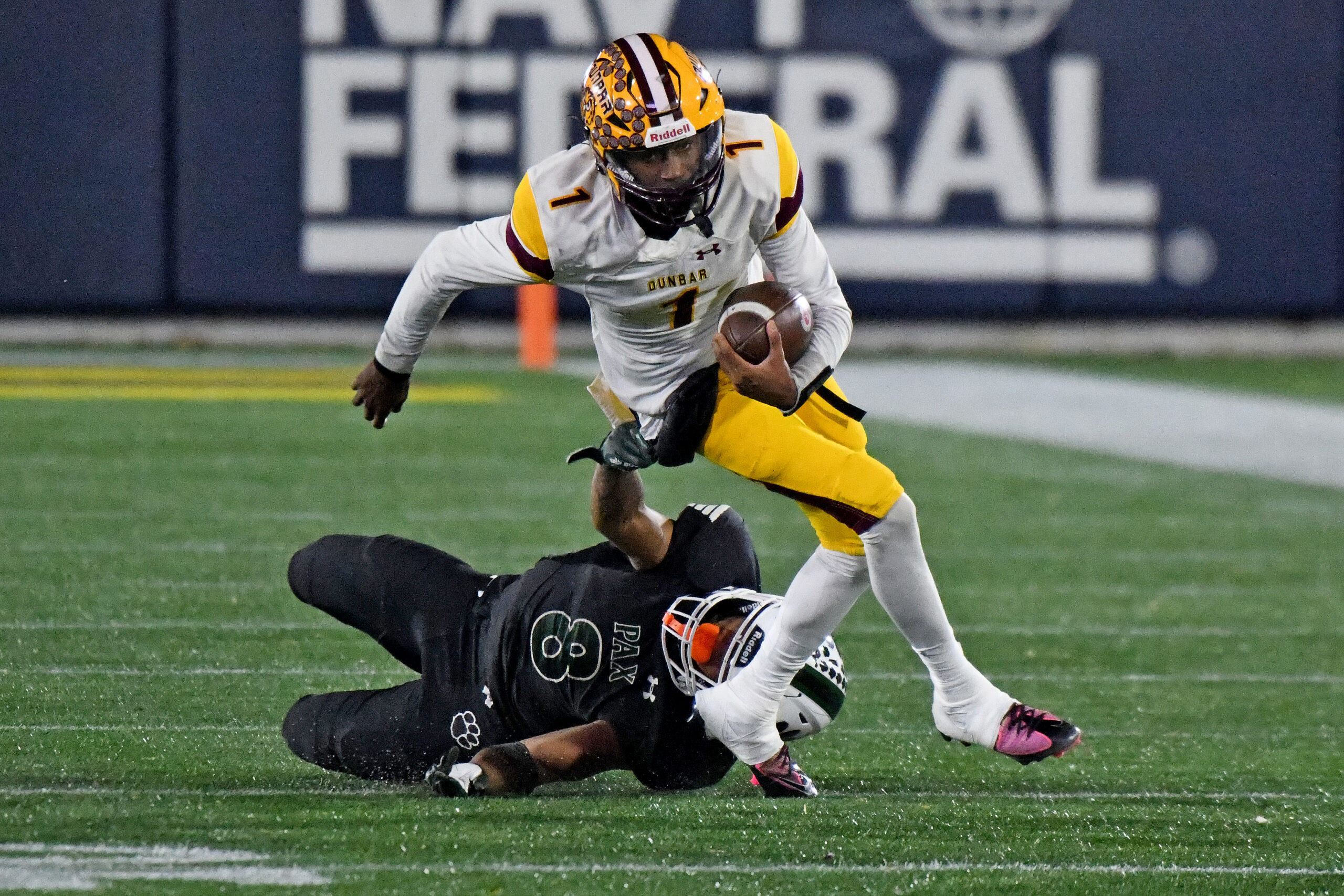 Marques Reid, Patuxent, slows Dunbar QB Savion Witherspoon in the...