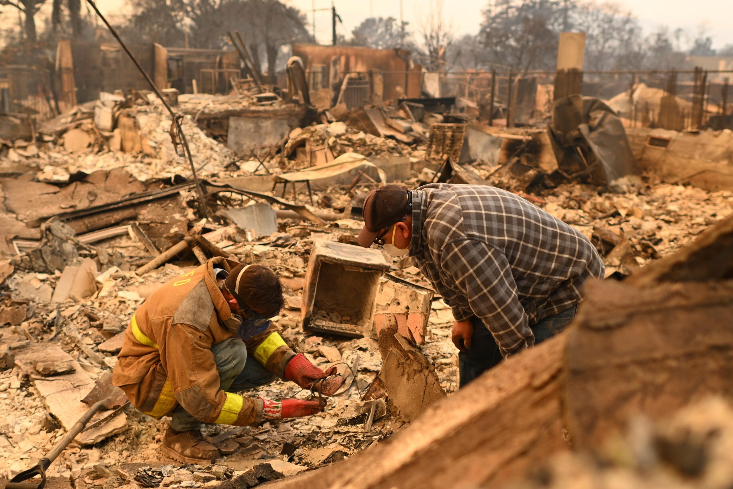 Robert Lara, left, looks for belongings along with his stepfather...