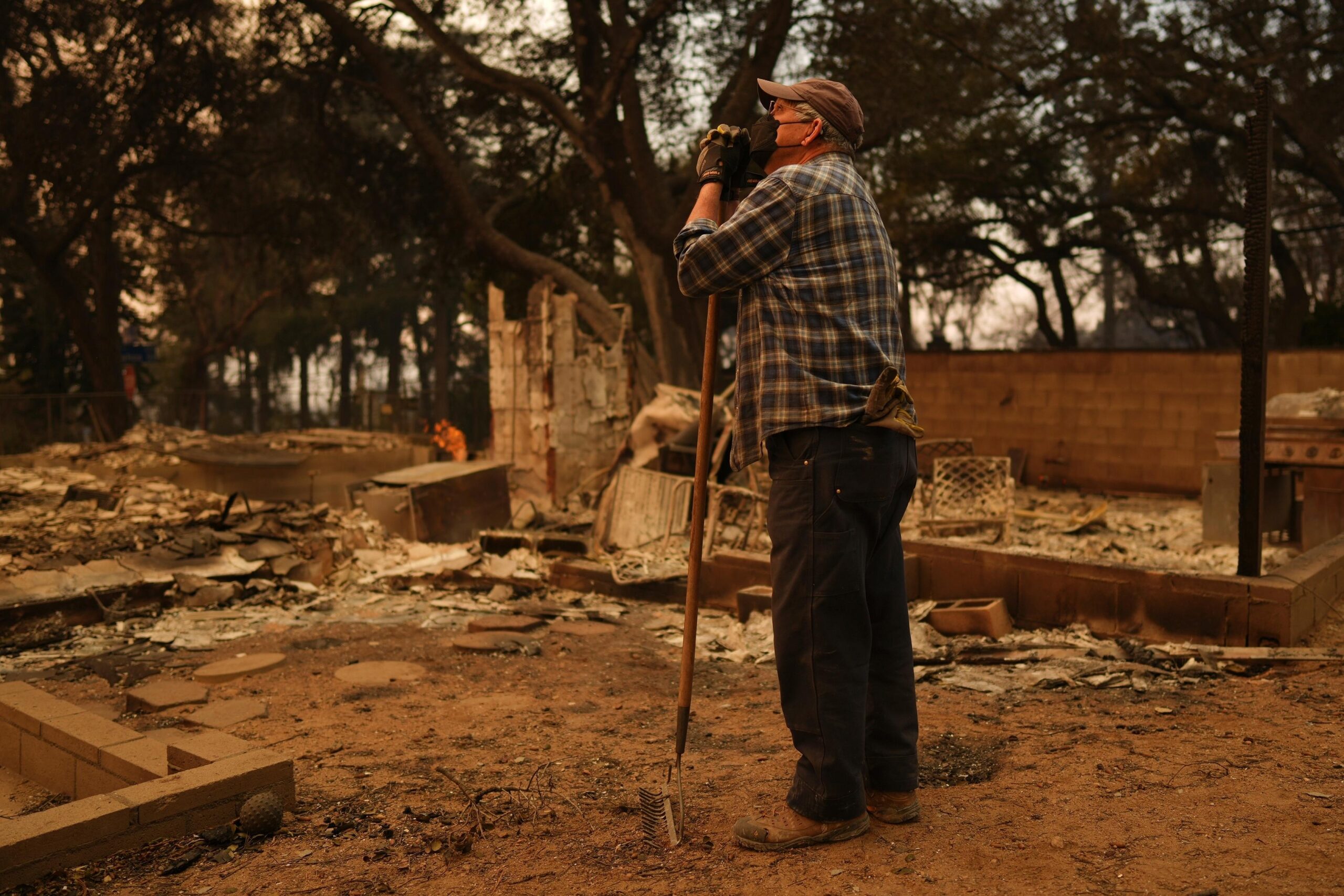 Paul Perri searches through his daughter’s fire-ravaged property in the...